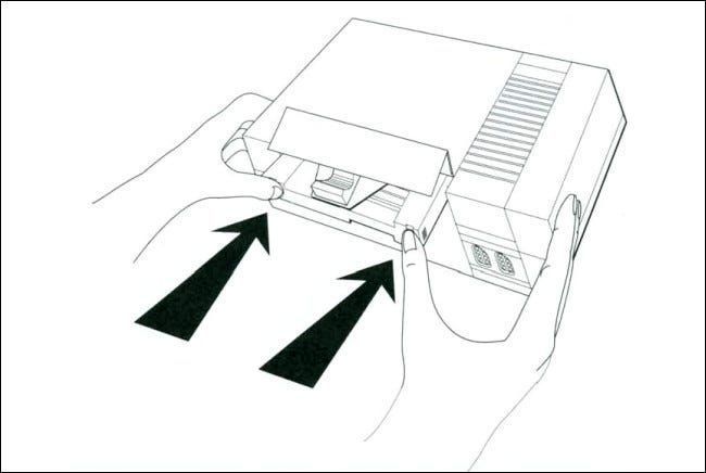 গেম জিনি ম্যানুয়াল থেকে NES-এ গেম জিনি ঢোকানোর একটি লাইন ডায়াগ্রাম।