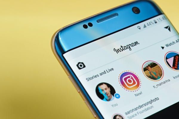 Aplikacija Instagram otvorena na pametnom telefonu koja prikazuje priče i feedove uživo.