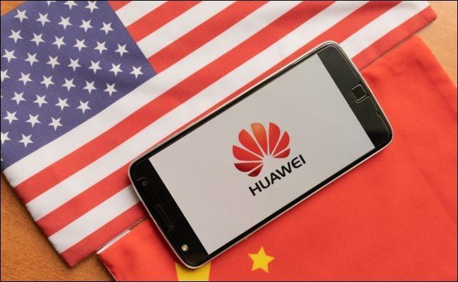 Хуавеи телефон између заставе САД и Кине.