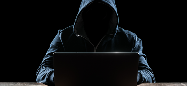 Хакер с качулка пред компютъра си