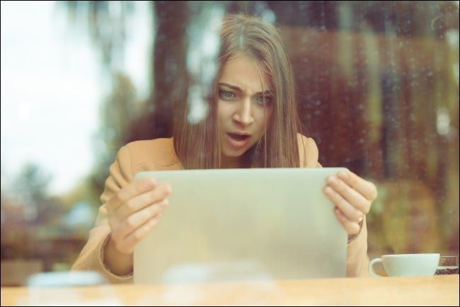 Шокирана жена държи лаптопа си