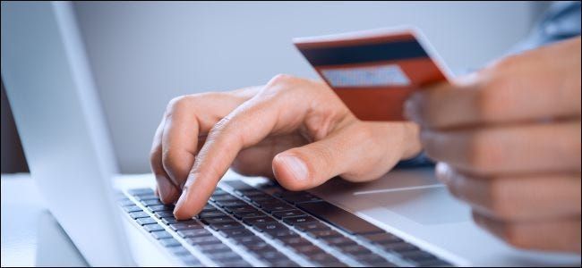 Ένα άτομο που κρατά μια πιστωτική ή χρεωστική κάρτα ενώ πληκτρολογεί σε φορητό υπολογιστή.