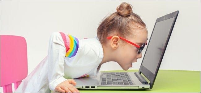 Παιδί με γυαλιά που κλίνει σε φορητό υπολογιστή